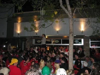 A woman teases the crowd as the crowd taunts her to bare her breasts.