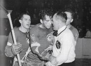 A bloodied Jimmy Orlando after a stick swinging fight with Leafs Gaye Stewart leans against King Clancy, November 7, 1942.