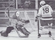 Bruce Boudreau shoots on Bob Johnson, 1975-76 season action.
