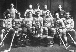 The Quebec Bulldogs team after their second consecutive Cup victory; Moran is seated third from the left, next to Joe Malone, and between the O'Brien Trophy and the bulldog.