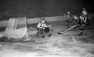 Frank Brimsek stops Bill Carse in this 1942 playoff game. #21 Jack Shewchuk slides by while #4 Herb Cain looks on.