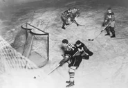 Hawks Johnny Gottselig rounds the net past Maroons Flat Walsh on December 12, 1929.