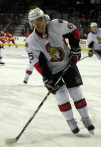 Man skating on rink wearing hockey equipment