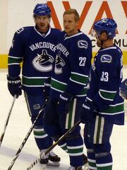Ballard (left) stands with Canucks teammates  and .