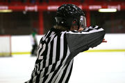 A youth hockey official signalling an icing call.