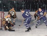 Terry Sawchuk stops Dick Duff in 1955-56 action.