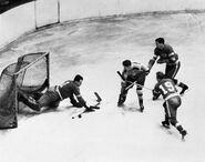 Johnny Mowers stops Bobby Bauer with #19 Connie Brown in Game 2, April 8, 1941.