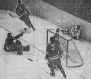 Bob Beckett crashes into the boards after scoring on Gump Worsley, November 8, 1961.