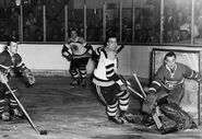 Jacques Plante deflects the puck past Jerry Toppazzini as Don Marshall and Don McKenney look on during Game 2 of the 1958 Finals, April 10, 1958.