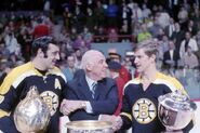 Clarence Campbell presents trophies to Phil Esposito and Bobby Orr for the 1968-69 season.