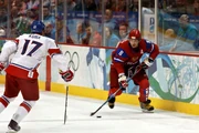  of the  moves the puck as   defends against him, during the 2010 Olympics