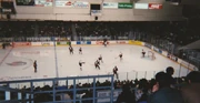men on skates playing ice hockey in an arena