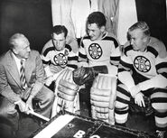 Coach George Boucher, Milt Schmidt, Jack Gelineau and Bill Quackenbush prior to an exhibition game, October 1949. Note the 25th anniversary jerseys from the previous season.