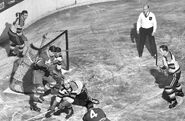 Jack Crawford clears the puck away from Leafs #4 Harry Watson while goalie Frank Brimsek, #9 Jimmy Peters and Pat Egan watch during the 1949 Semi-finals.