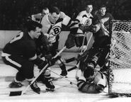 Bruins Jim Henry stops Gordie Howe while Metro Prystai looks on in Game 6 of the 1953 Semi-finals, April 5, 1953.