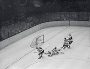 Doug Mohns is stopped by Johnny Bower while Jack Evans holds off Murray Costello, November 24, 1954.