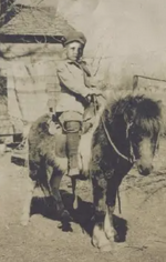 Indy riding a pony at his 's ranch.