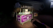 A concession stand with an ice cream cooler beside it.