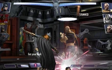 Batgirl rescues Arkham Origins Bane while also stunning the opponent with a smoke bomb.