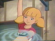 Penny, with one of her hands cuffed to a rail, uses the magnet on her wristwatch to grab a set of keys