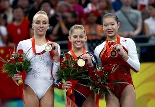 Johnson (center) with her Olympic Balance Beam gold medal