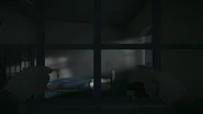 Franklin tied to his chair as seen from the other cell
