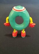 A green Ollie bendable figure from the back