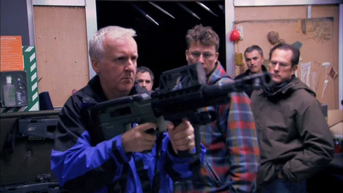 James Cameron Pokazuje strzelbę śrutową CARB. na zdjęciu brań na otwarty zamek i okno wyrzutnika łusek