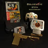 Multiple GoldenEye 007 box/cartridges alongside replica props of the GoldenEye Key and Golden Gun, signed by a few developers for a professional tournament fan, to promote the game's 25th anniversary (2022)
