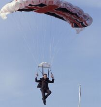 Gustav Graves arrives at his knighting ceremony by parachute.