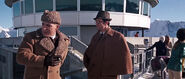 Bond and Blofeld conversing on the ice patio as the girls play curling.