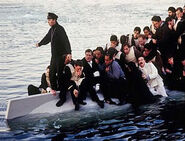 Harold Bride behind Charles Lightoller (standing) on the upturned Collapsible B Lifeboat in a deleted scene