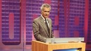 A close up look at Alex Trebek in front of his podium.