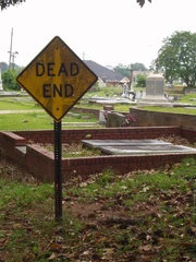 A cemetery with a "Dead End" sign, creating an amusing 