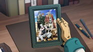 Jotaro, in his office, holds the photo of his old friends