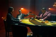 Killa aiming his gun at John Wick whilst Caine aims his gun at Killa