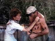 Sayer removing leeches from her husband, Charlie Allnut