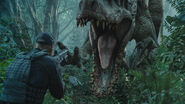 Miller firing at the Indominus rex as she charges at him.