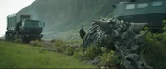 Cut scene of Peloroplites skeleton lying on the ground while trucks pass by it.