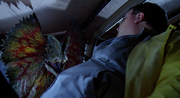 Dennis is ambushed in his Jeep by the Dilophosaurus.