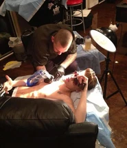Justin getting his mother's birthday tattoo (in roman numerals)