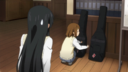 Yui tells Mio's bass to have fun with Gita.