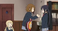 Yui feeds Azusa cake.