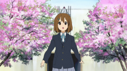 Yui Hirasawa standing under the cherry blossom trees that gave the school its name.