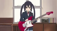 Azusa attempts to practice while everyone's having tea.