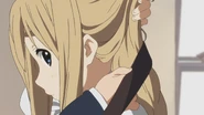 Tsumugi putting Azusa's guitar on.