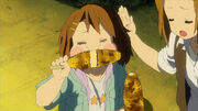 Yui demonstrates how to eat grilled corn.