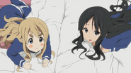 Mio being unsure about continuing the pillow fight, unlike the eager Mugi next to her.