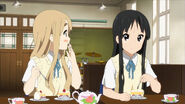Tsumugi steals the strawberry off of Mio's cake.