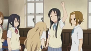 Mio hesitating to hit Tsumugi.